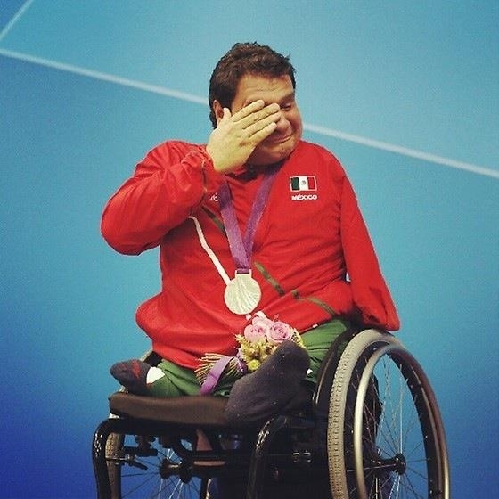 atleta paraolímpico emocionado ao ganhar medalha de ouro nas paraolimpíadas